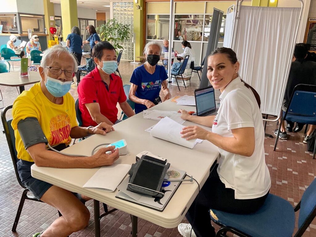 Group of seniors getting health screenings at a community clinic table.